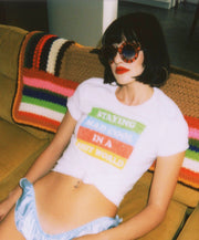 Girl wearing white cotton t-shirt that says Staying Mad Cool in a shit world.